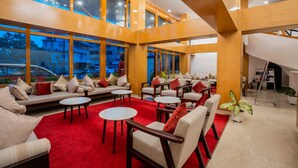 A spacious lobby with multiple seating areas, large windows, and a red carpet. - SUMMIT GRAND RESORT & SPA , GANGTOK  (Gangtok)