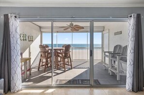 A room with a sliding glass door leading to a balcony with a view of the ocean. - Oceanfront Three Bedroom Condo on the Boardwalk (Ocean City)