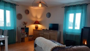 Een gezellige kamer met een bed, een bureau, een televisie en een open haard.
