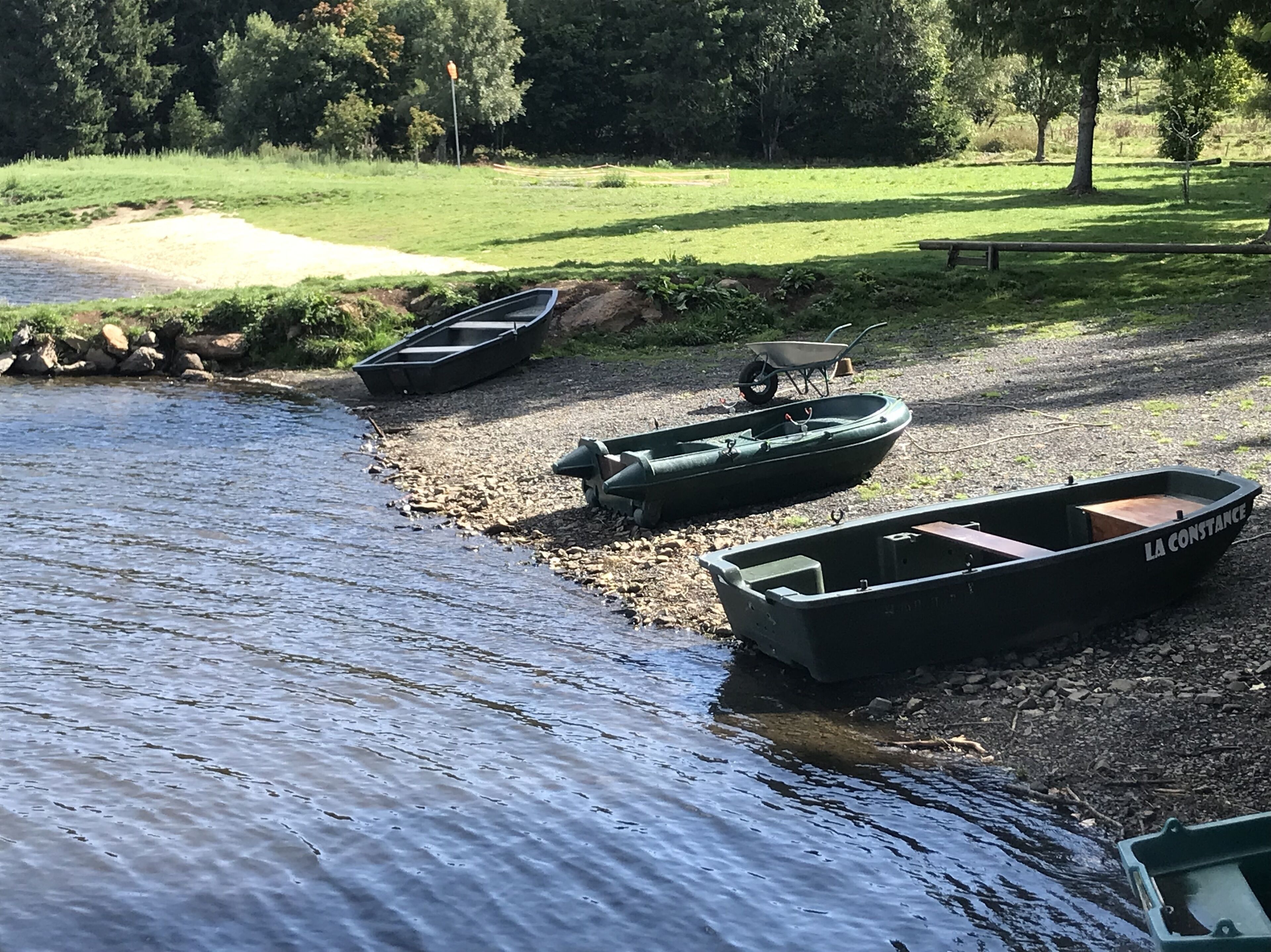 A riverbank with boats and a wheelbarrow.
