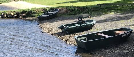 A riverbank with boats and a wheelbarrow.