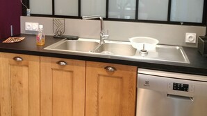 Een moderne keuken met houten kastjes, een roestvrijstalen spoelbak en een vaatwasser.