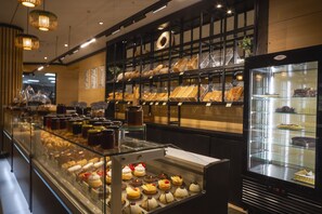 A bakery display with various baked goods and pastries. - Eko Hotel Gardens (Lagos)