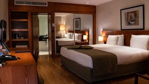 Habitació d'hotel amb un llit gran, taules de nit, un escriptori amb un telèfon i un mirall.
