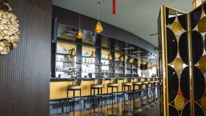 Un bar amb un taulell corbat, diverses tapes i llums penjants.