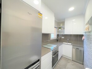 A modern kitchen with white cabinetry, stainless steel appliances, and a tiled backsplash. - T-0322, Mariposa, Modern villa in Dènia (Dénia)