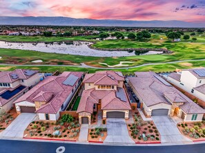 A residential area with houses featuring red-tiled roofs, a golf course, and a body of water. - Desert Oasis Retreat | EV Charger, GolfCourseViews (La Quinta)