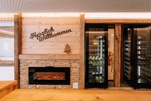 Eine Holzwand mit Kamin und einem Schild mit der Aufschrift 'Herzlich Willkommen'.