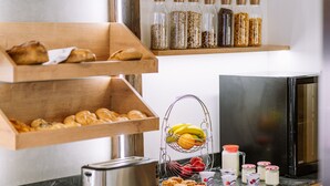 Un buffet de petit-déjeuner proposant un assortiment de viennoiseries, de fruits et de condiments.