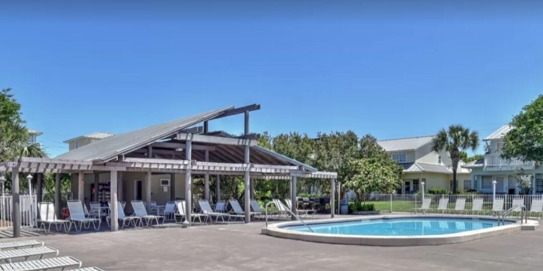 Zona de piscina coberta amb gandules i una piscina.