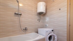 A bathroom with a bathtub, a washing machine, and a water heater. - Anto - 3 bedroom apartment in Trogir (Trogir)