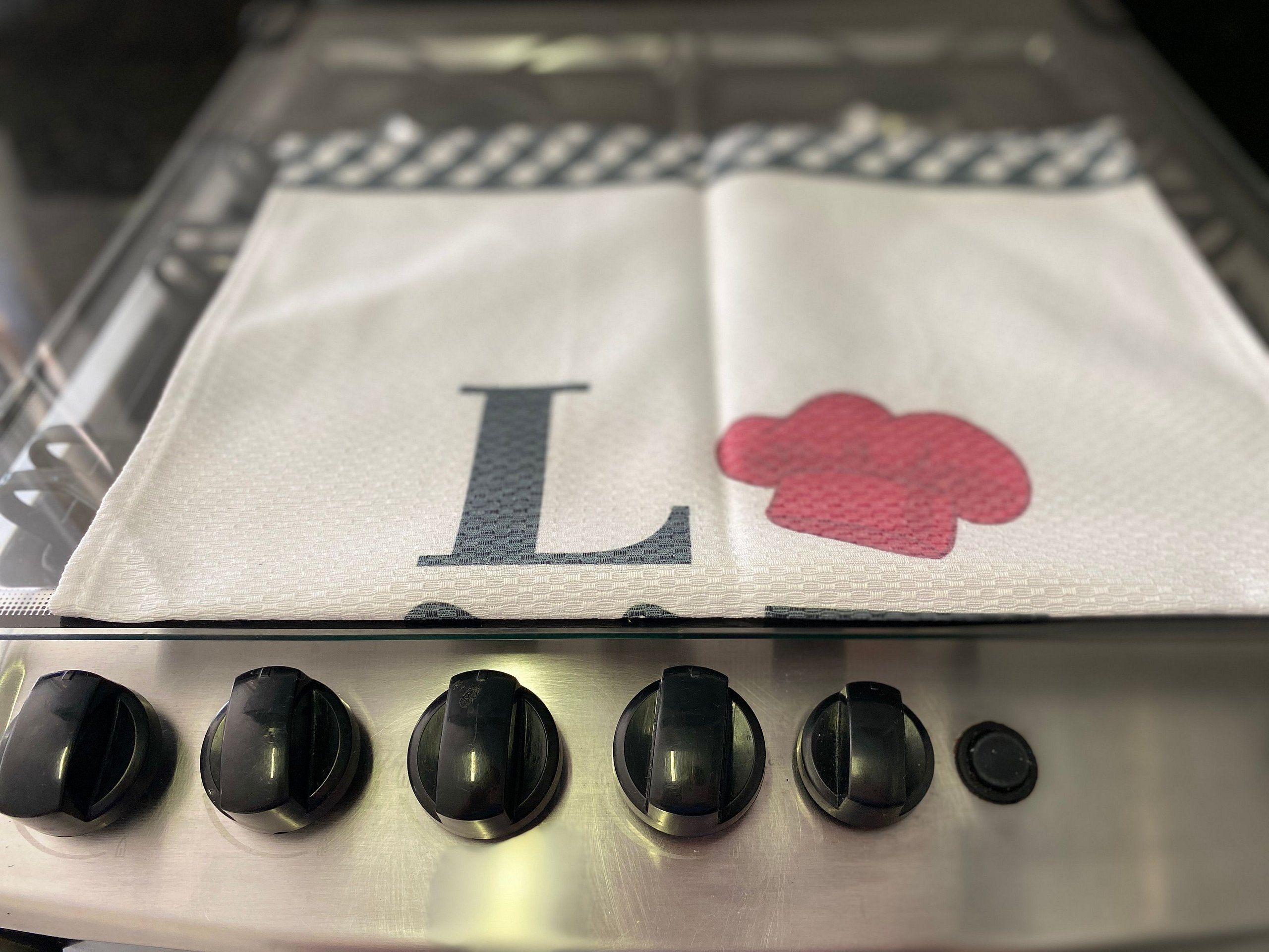 A kitchen with a stainless steel stove and four knobs.