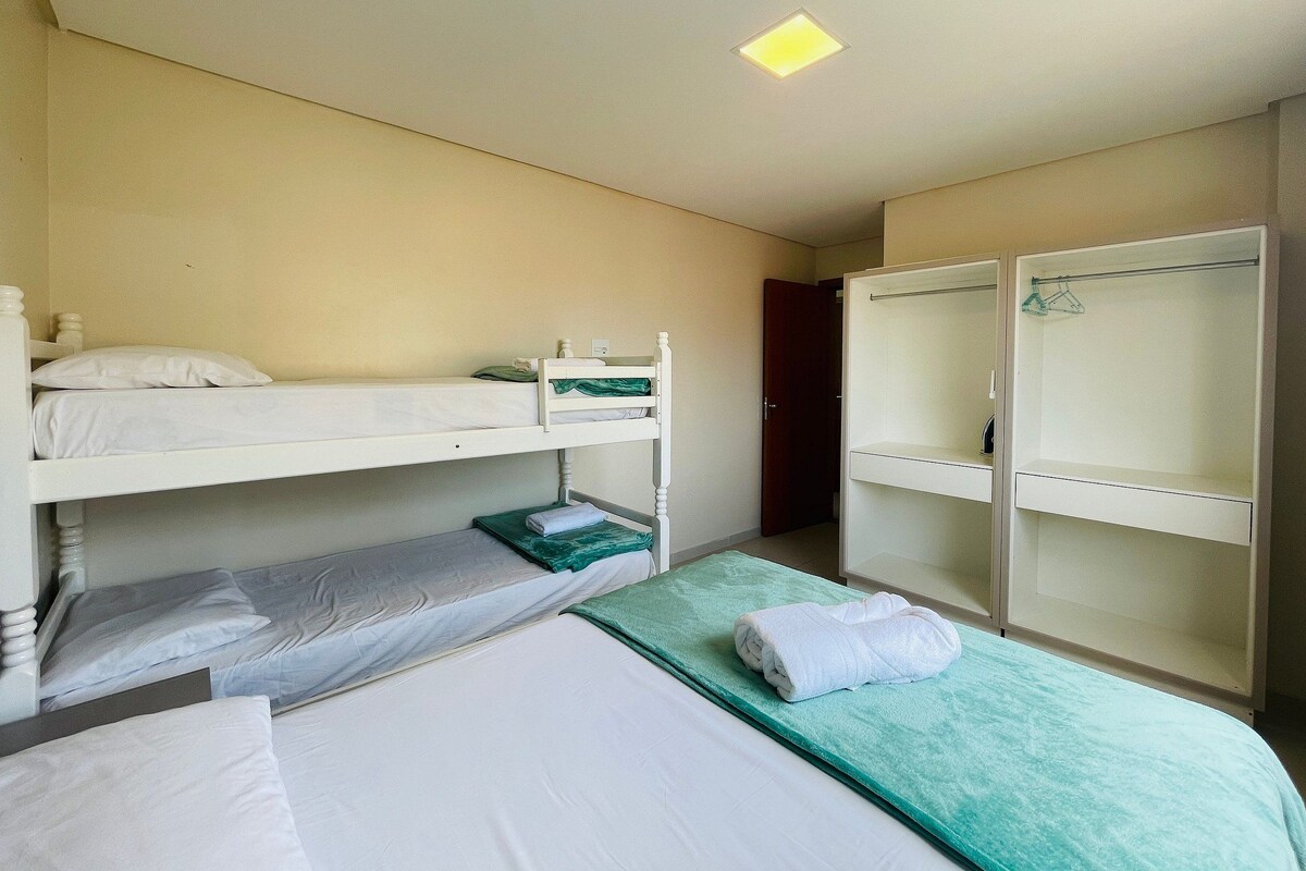 Habitación tipo dormitorio con literas, un armario y una lámpara en el techo.