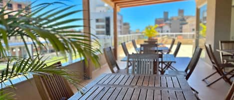 Une terrasse en bois, agrémentée de tables et de chaises, d’où l’on peut admirer la vue sur la ville.