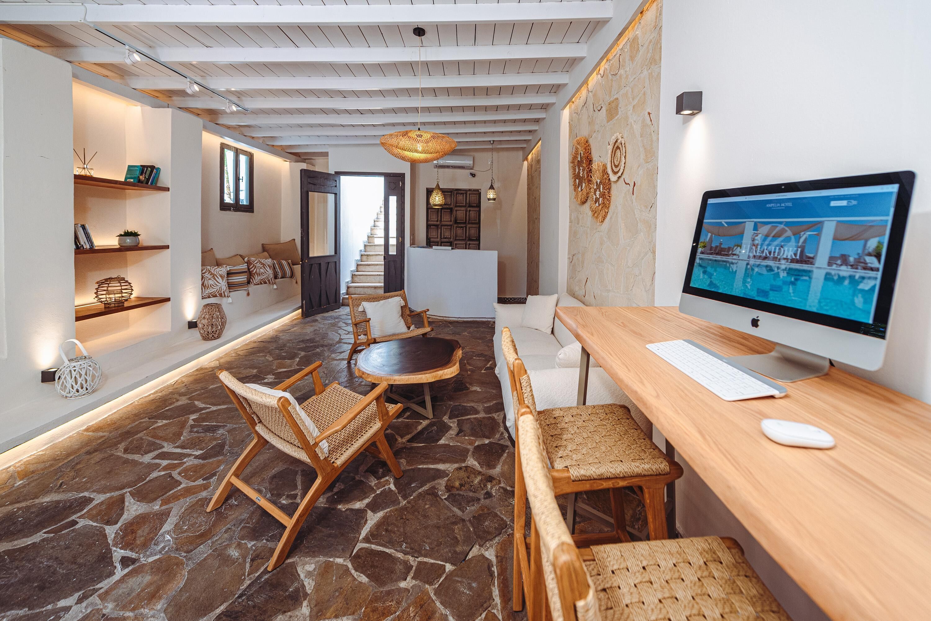 Una sala de estar moderna con piso de piedra, muebles de madera, un televisor de pantalla plana grande y una escalera que sube a otro nivel.