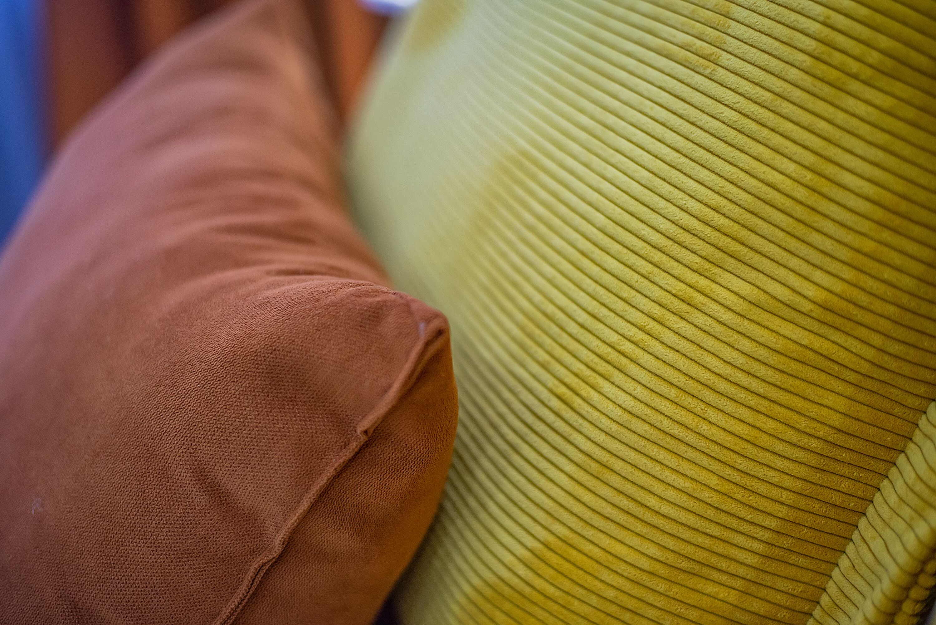 A close-up of a textured yellow pillow and a brown pillow.