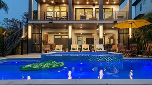 Ein modernes, zweistöckiges Haus mit Schwimmbad, Außenbereich und einer Treppe.