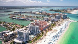 Eine Küstenstadt mit Strand, Hochhäusern und einer Brücke.