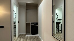 A hallway with a wooden floor, a built-in wardrobe, and a large mirror on the wall. - CC Opera Suites (Madrid)