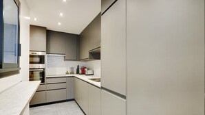 A modern kitchen with built-in appliances, a countertop, and a window. - A Stunning 2-BR/2BA with Terraces and A/C (Paris)