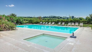 A rectangular swimming pool with a small hot tub, surrounded by lounge chairs and greenery. - Tenuta di Palù (Bardolino)
