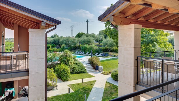A covered outdoor area with a pool, lounge chairs, and a garden. - Tenuta di Palù (Bardolino)