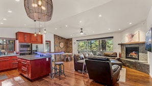 A spacious living area with a fireplace, a kitchen with wooden cabinets, and a dining area. - Chaco Trail | 2BR / 2BA | | Spend Spring in Flagstaff! (Flagstaff)