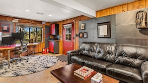 A cozy living room with a leather sofa, a wooden desk, and a fireplace. - Chaco Trail | 2BR / 2BA | | Spend Spring in Flagstaff! (Flagstaff)