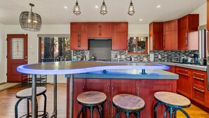 A modern kitchen with a central island, bar stools, and pendant lighting. - Chaco Trail | 2BR / 2BA | | Spend Spring in Flagstaff! (Flagstaff)