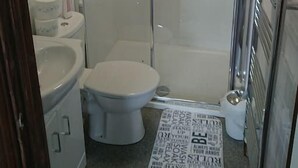 Ein Badezimmer mit einer Duschkabine, einer Toilette und einem Bidet.