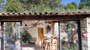 A covered outdoor dining area with a stone wall, wooden furniture, and potted plants. - Wonderful private villa for 4 people with WIFI, private pool and TV (Lentier)