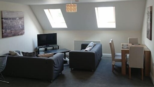 A loft-style living room with a TV, sofa, and dining area. - 1 Wood Yard Cottages. 2 Bedroom, Large lounge (Long Sutton)