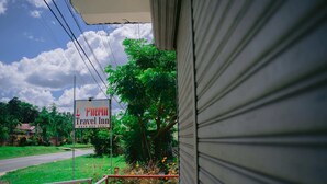 A travel inn sign with a view of a road and greenery. - L'Puerta Travel Inn (Hinoba-an)