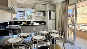 A modern kitchen with a dining area set for six. - Canto do Corrupião (Bombinhas)