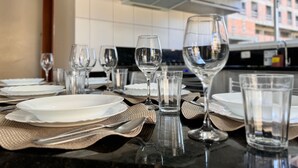 A modern kitchen with a dining area set for a meal. - Canto do Corrupião (Bombinhas)