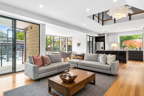 Relax in this open-plan living area with a sofa set against a glass wall offering a view of the outdoors.