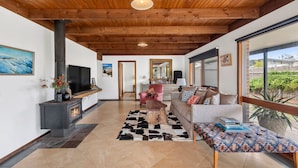 A modern living room with a fireplace, a sofa, a coffee table, and a television. - Aireys Rivermouth House (Aireys Inlet)