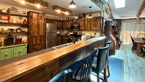Una cocina rústica con armarios de madera, una isla central y taburetes de bar.