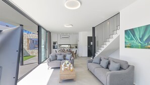 A modern living room with a sofa, coffee table, and a staircase leading to another level. - Villa Elise, Stunning and Brand New 3BDR Protaras Villa with Private Pool (Protaras)