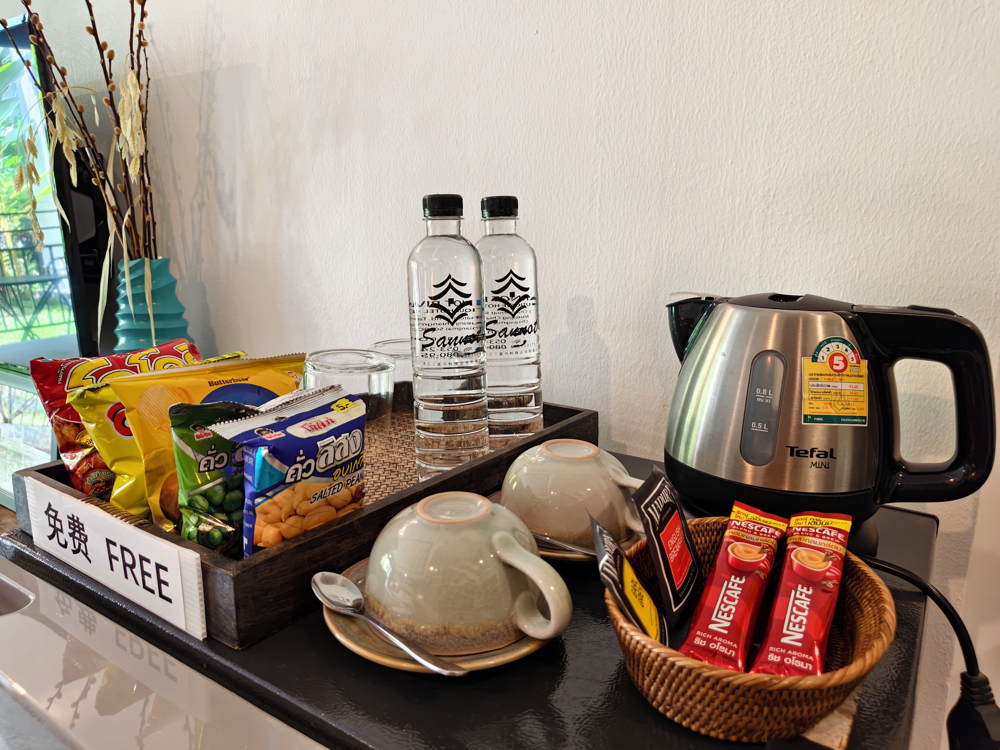 A breakfast buffet with snacks, beverages, and a coffee maker.