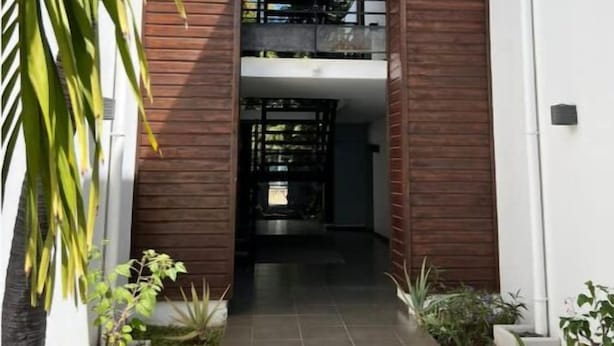 A modern building with a central open space, flanked by wooden panels and a tiled floor. - Ô Lagon Accès Direct Plage (LA SALINE LES BAINS)