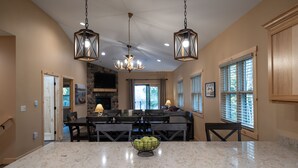 A spacious kitchen with a marble countertop, wooden cabinetry, and a central island. - New! 4BR Lake Namakagon Cabin - Sleeps 15 - Lakefront w/ boat access (Cable)