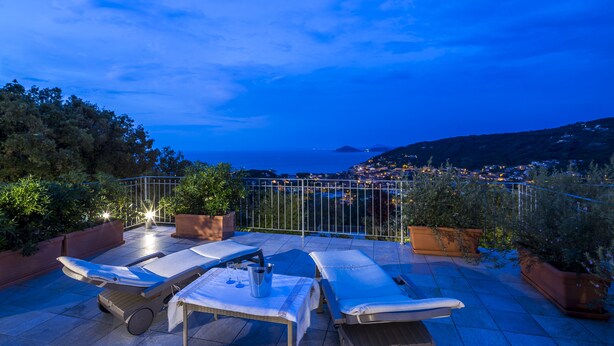A rooftop terrace with lounge chairs, a table, and potted plants. - Borgo dell'Uccellaia - Smeraldo (Marciana Marina)