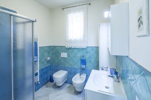 Een douche, een haardroger, een bidet, handdoeken