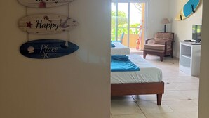 Ein Schlafzimmer mit einem Bett, einem Sessel, einem Nachttisch und einem Surfbrett an der Wand.