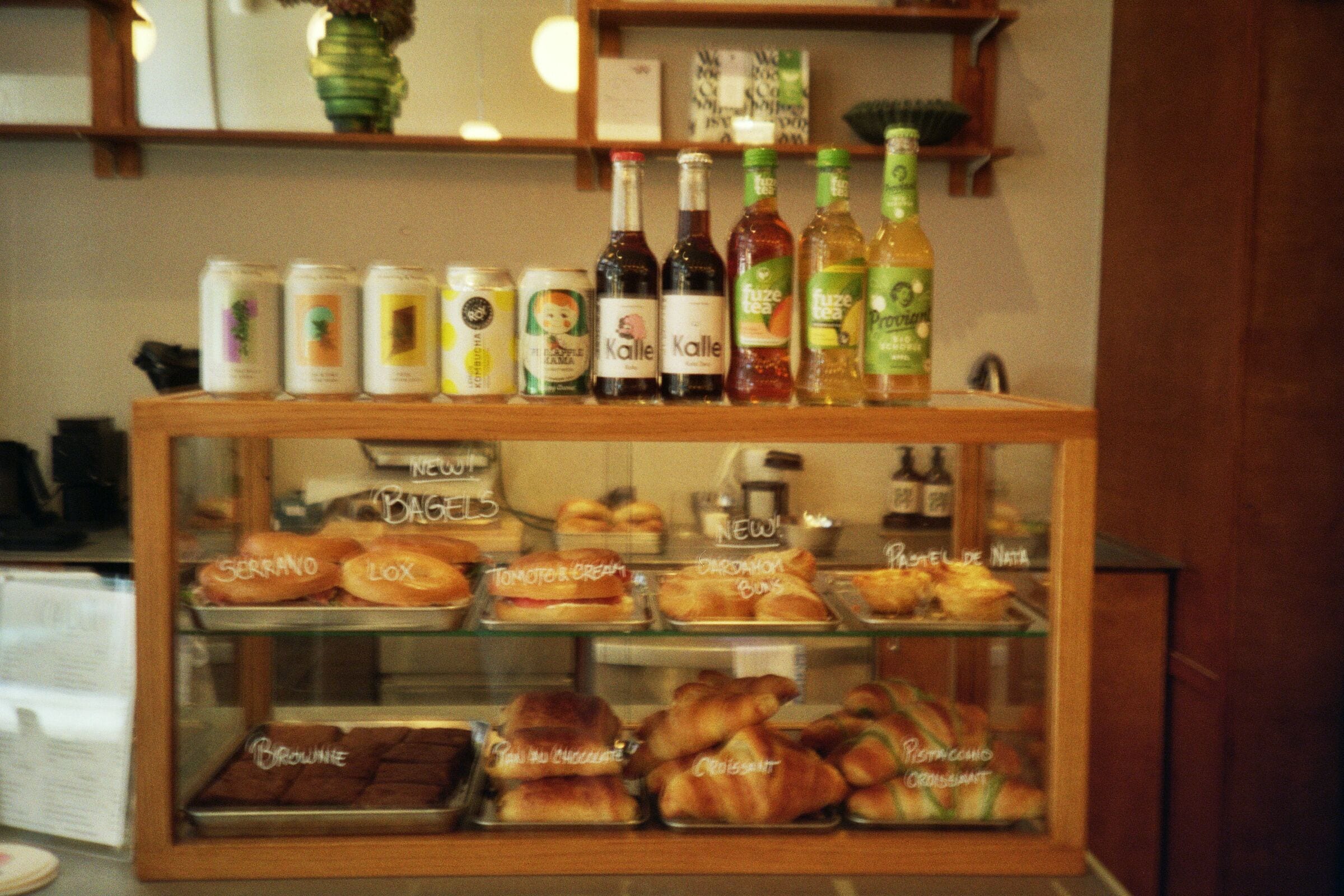 A bakery display with various baked goods and a selection of beverages.