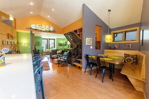 Una cocina amplia con comedor, una escalera y vista al salón.