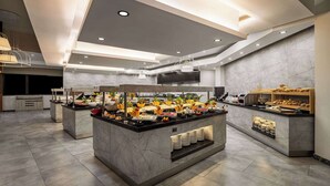 Una cocina moderna con encimeras de mármol, una isla central con exhibición de alimentos e iluminación empotrada.