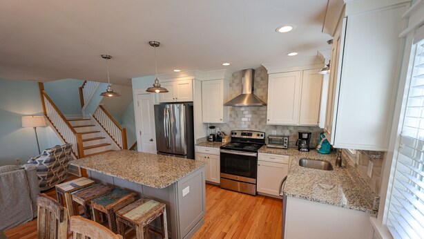 A modern kitchen with granite countertops, stainless steel appliances, and a central island. - M931- Sound Side, Corolla, Saturday Check In, Comm. Pool! (Corolla)