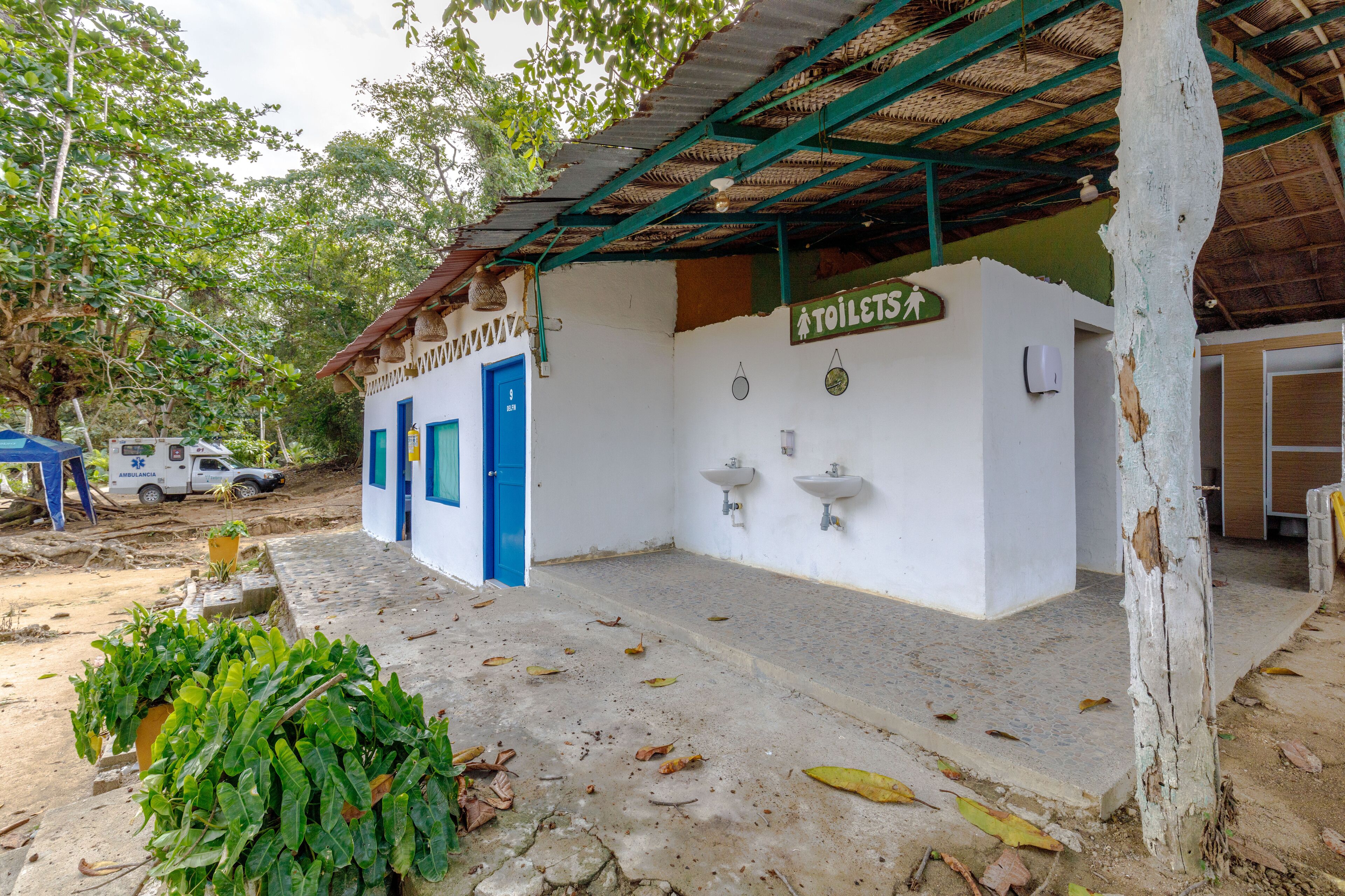 A small building with a blue door and a sign indicating a toilet facility.